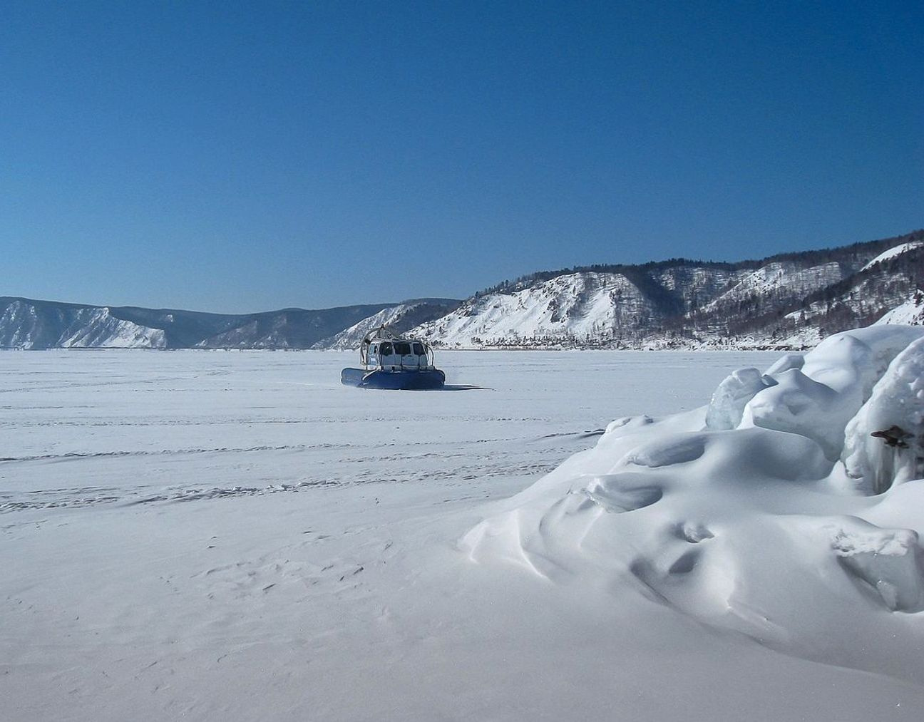 Una guida che legge le previsioni meteo accanto a una finestra che guarda verso il lago